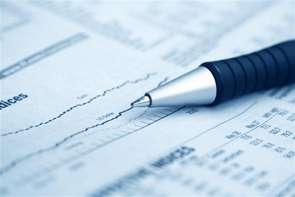 Blurred financial graph paper with pen laying on it