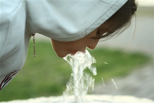 Girl drinking from water fountain. Girl drinking from water fountain.