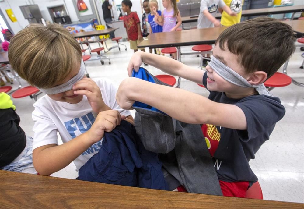  Two students working with blindfolds on
