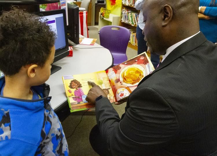  Eric Kirkman reading a book to a student